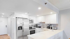 Een moderne keuken met witte kasten, roestvrijstalen apparatuur en een centraal eiland.