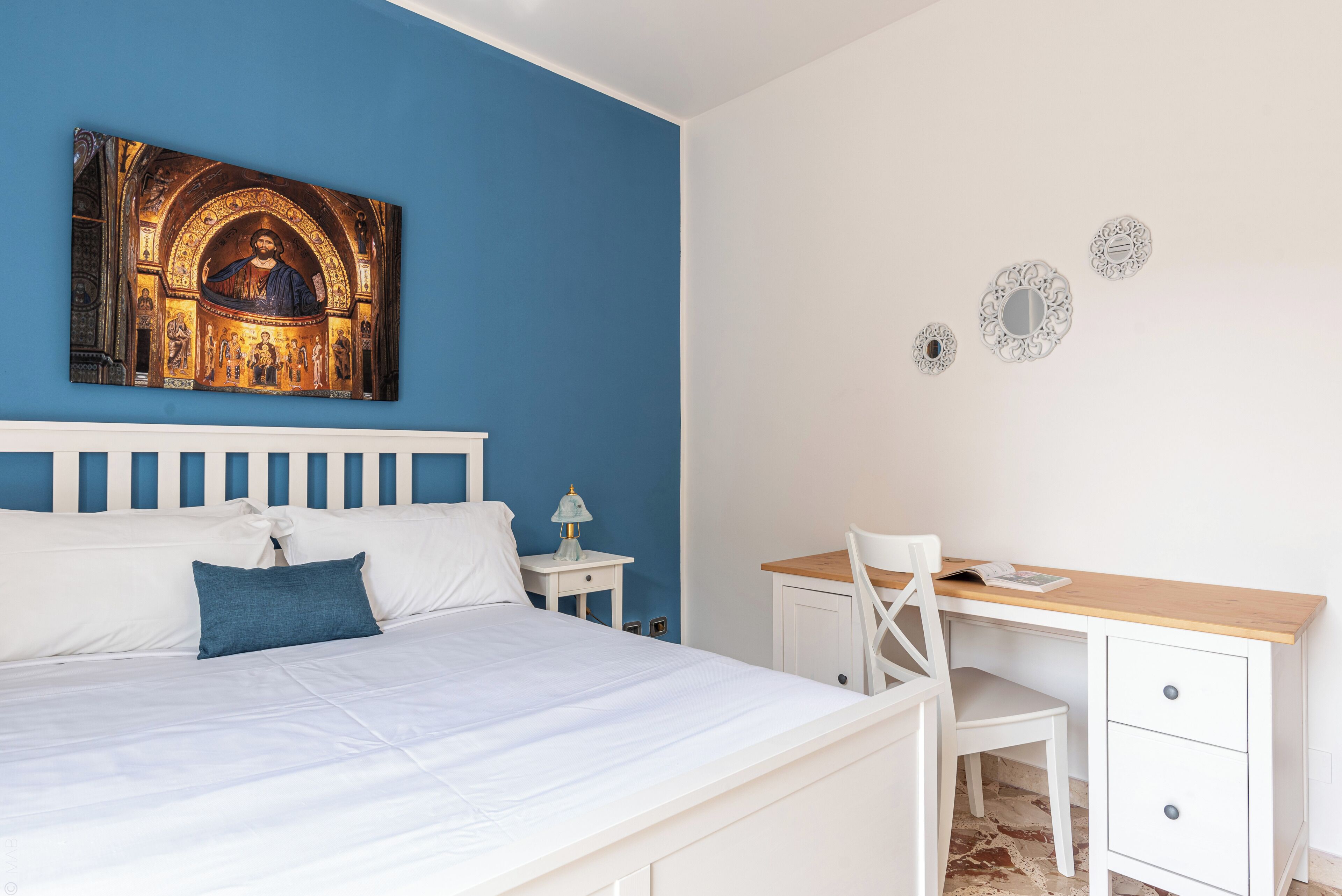 Una camera da letto con un letto, una scrivania e una sedia.