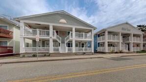 A beachfront hotel with a two-story structure, balconies, and a covered front porch. - Newly remodeled, ocean block condo with balcony, central AC & W/D (Ocean City)