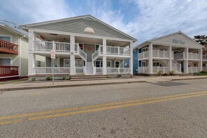 A beachfront hotel with a two-story structure, balconies, and a covered front porch. - Newly remodeled, ocean block condo with balcony, central AC & W/D (Ocean City)