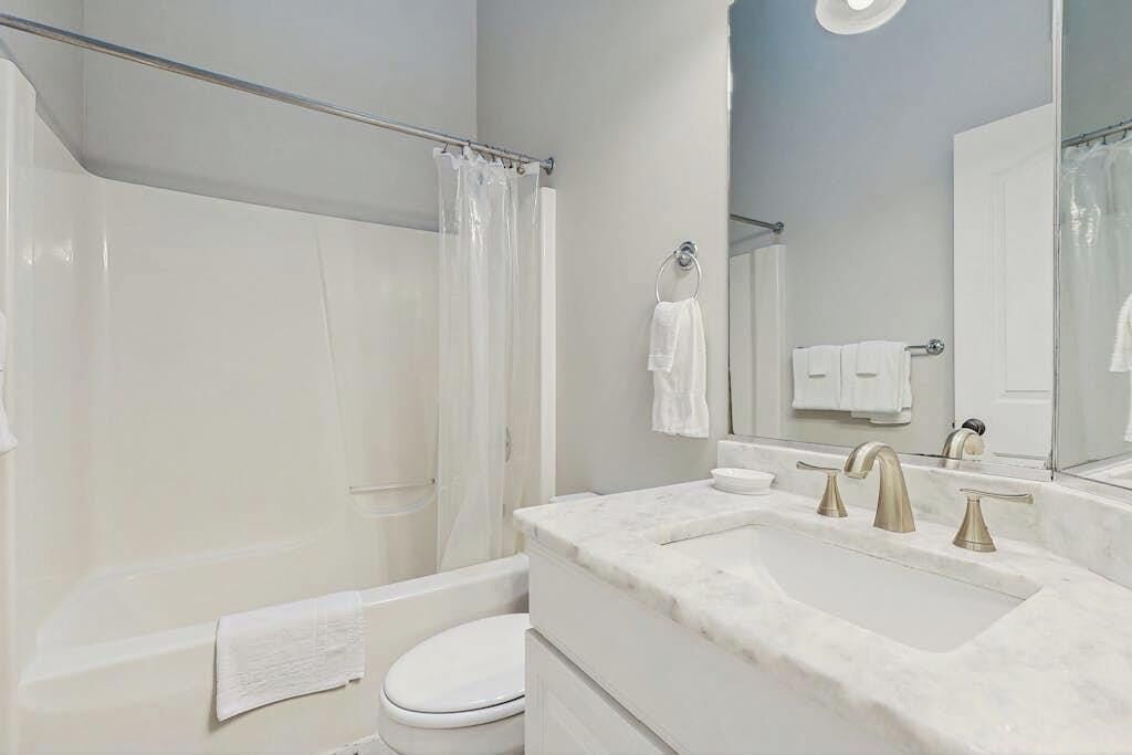 A bathroom with a bathtub, toilet, and sink.