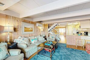 Ein Wohnzimmer mit Sofa, Couchtisch, Lampe und einem Gemälde an der Wand.