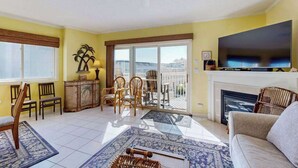 Un salón con chimenea, televisor y balcón con vistas.