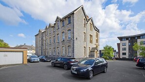 Un immeuble à plusieurs étages avec un parking situé à l’avant.