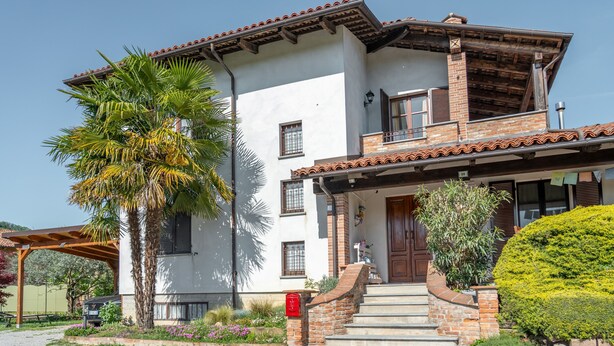 A two-story house with a balcony, a front door, and steps leading to the entrance. - Ca' Felicina - Two Bedroom Apartment, Sleeps 4 (Alba)