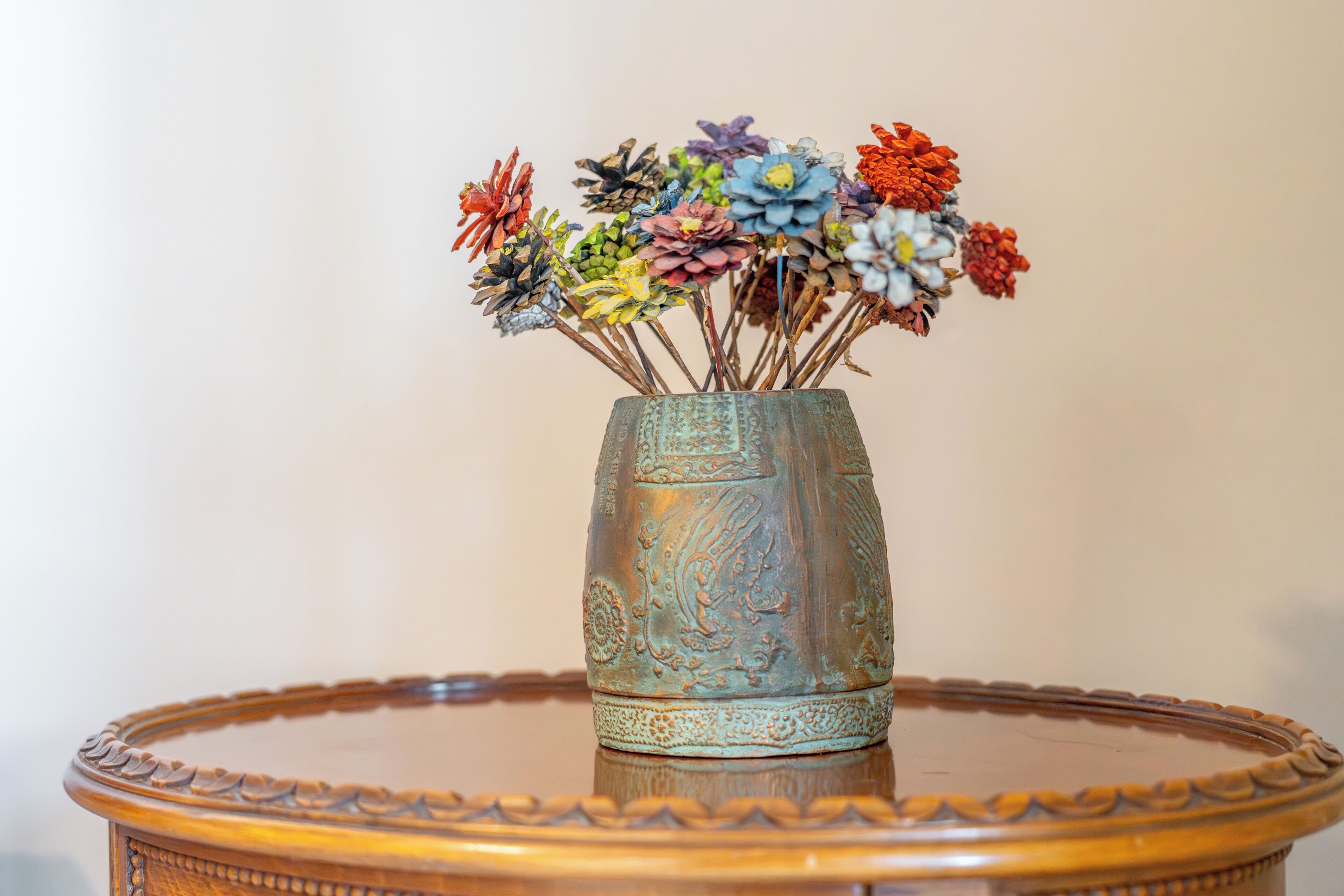 A decorative vase with a textured surface and a circular table with a scalloped edge.