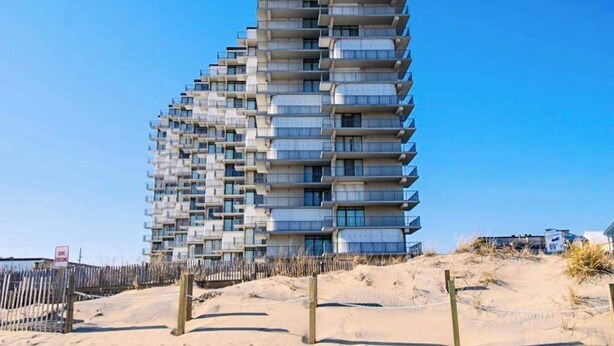 Ein mehrstöckiges Gebäude mit Balkonen in Strandnähe.