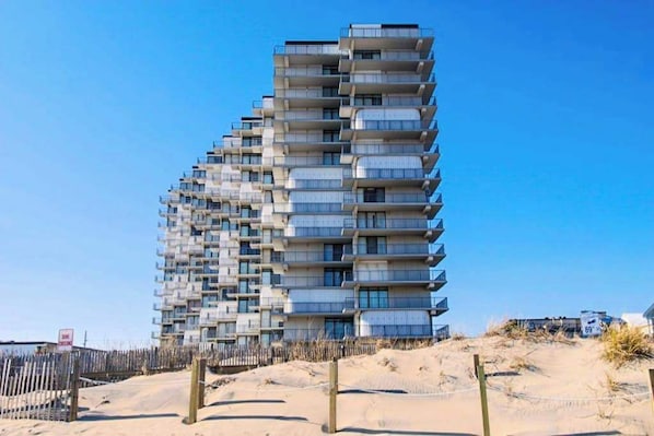 Ein mehrstöckiges Gebäude mit Balkonen in Strandnähe.