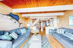 Ein modernes Interieur mit zwei Sofas, einem Couchtisch und einer Holzbalkendecke.