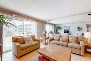 A modern living room with two sofas, a coffee table, and a TV. - Inviting Beach Condo w/Private Balcony, Great Location, Washer/Dryer, Central AC (Ocean City)