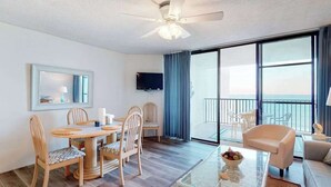 Une chambre d’hôtel dotée d’un coin repas, d’un balcon avec vue, d’un ventilateur de plafond et d’un téléviseur à écran plat.
