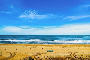 Ein Strand mit einem eingezäunten Bereich, feinem Sand und dem Meer.