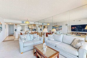 Ein modernes Wohnzimmer mit einer Sofagarnitur, einem Couchtisch und einem Fernseher.