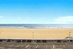 A beach view from a balcony with wooden railings and benches. - Beachfront Condo w/Private Balcony, Beach Views, Washer/Dryer, Central A/C (Ocean City)