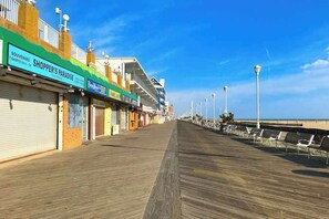 A boardwalk with shops, a beach, and a clear sky. - Ocean Club 4007 (Ocean City)