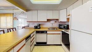 A compact kitchen with a dishwasher, microwave, and oven. - Ocean Block Condo w/ Side Ocean View, Balcony, WiFi, AC & Shared Pool (Ocean City)