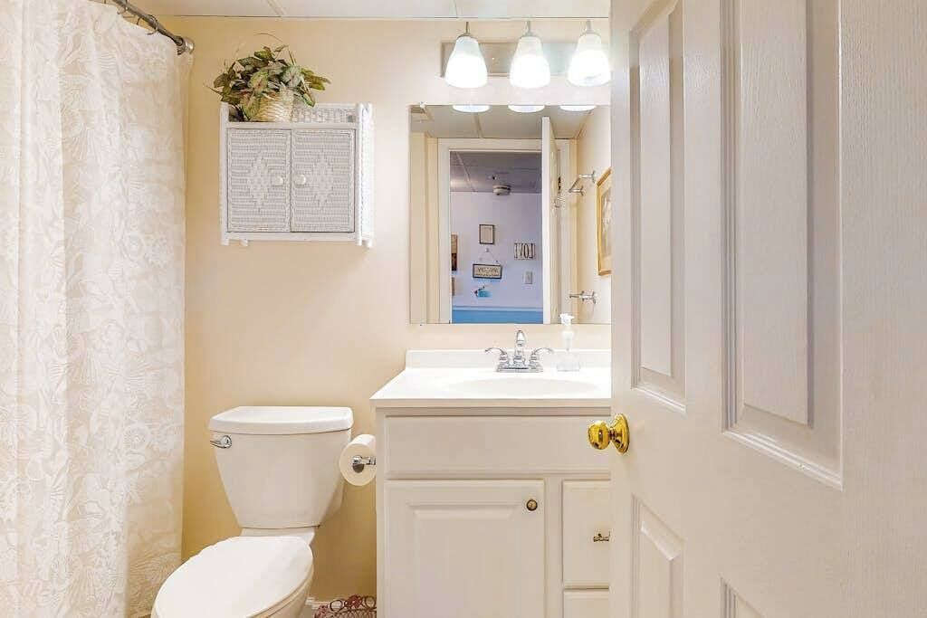 Een badkamer met toilet, wastafel en kast.