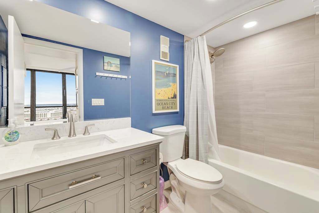 A bathroom with a dual sink vanity, a toilet, and a bathtub.