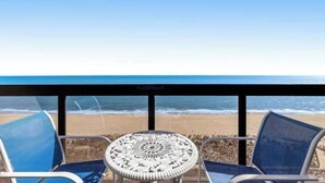 Vista sulla spiaggia dal balcone, con due sedie e un tavolo.