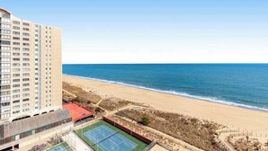 Un hotel moderno con campo da tennis e vista sulla spiaggia.