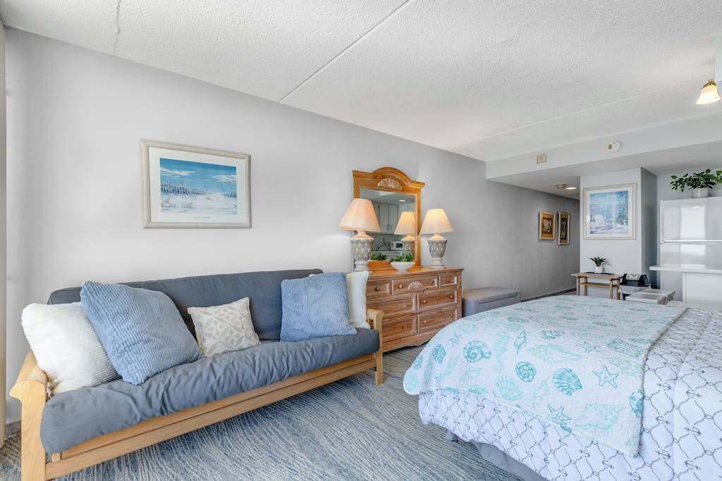 Une chambre à coucher avec un lit, un canapé, une commode et un miroir.