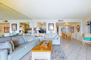Ein Wohnzimmer mit einer Couch, einem Couchtisch und einem Essbereich mit Stühlen.