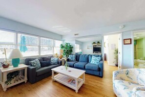 A living room with a sofa, coffee table, and a TV. - Steps to the beach - condo with 2 balconies, central AC & pool (Ocean City)