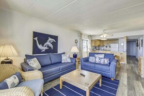 A living room with two sofas, a coffee table, and a painting on the wall. - Attractive Suite in Oceanfront Complex w/Free WiFi, Private Washer/Dryer, & AC (Ocean City)