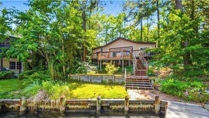 A house with a wooden deck, a staircase, and a pond. - Drawbridge Rd 38 (Ocean Pines)