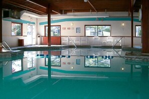 An indoor swimming pool with clear water, wooden beams, and windows. - Club Ocean Villa II 144 (Ocean City)