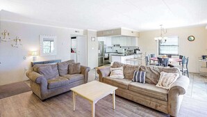 Ein Wohnzimmer mit zwei Sofas, einem Couchtisch und einem Essbereich mit Tisch und Stühlen.