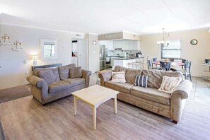 A living room with two sofas, a coffee table, and a dining area with a table and chairs. - Diamond Beach 117 (Ocean City)