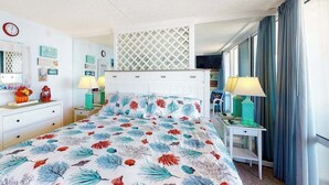Ein Hotelzimmer mit einem Bett, zwei Nachttischen, einem Fernseher und einem Fenster mit Vorhängen.
