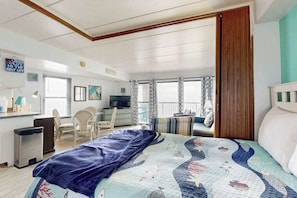 Ein Schlafzimmer mit einem Bett, einem Schreibtisch, einem Stuhl und einem Fenster.
