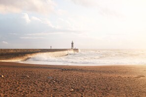 A beach with a lighthouse and a sea wall. - Porto Arts Club Apartment IV by Feel Discovery (Porto)