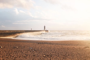 A beach with a lighthouse and a sea wall. - Porto Arts Club Apartment V by Feel Discovery (Porto)