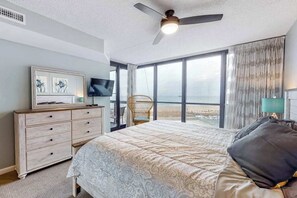 A bedroom with a bed, a dresser, a television, a chair, and a view of the ocean. - Oceanfront condo with ocean view, pools, tennis, sauna & central AC (Ocean City)