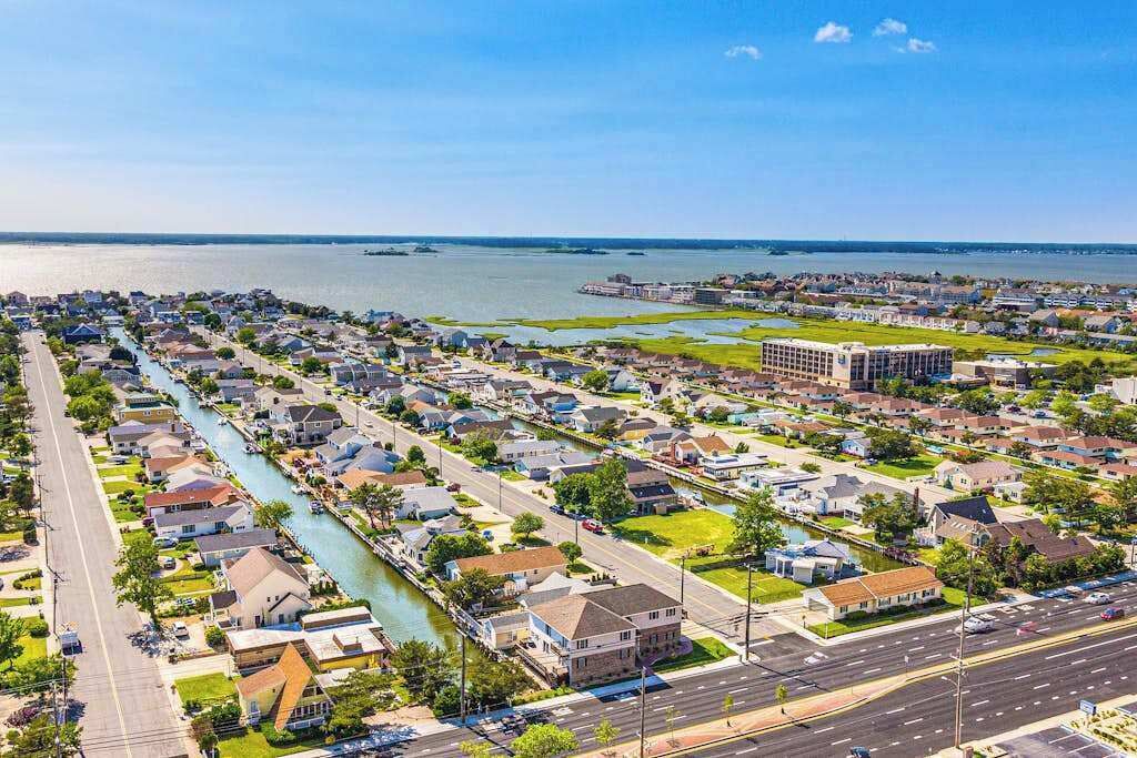 An aerial view of a residential area with houses, a river, and a large building.
