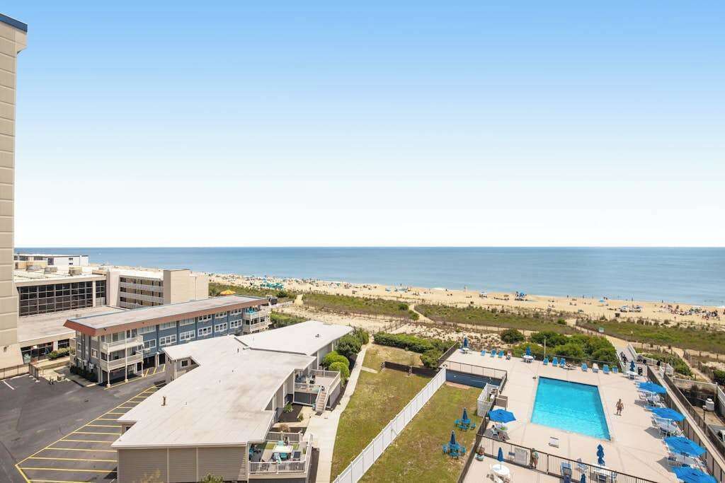 Ein Hotel mit Schwimmbad, Blick auf den Strand und Parkplatz.