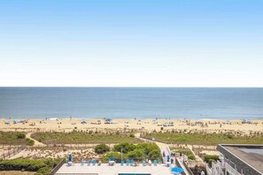 A beach view with a pool area, lounge chairs, and umbrellas. - Fountainhead Towers 802 (Ocean City)