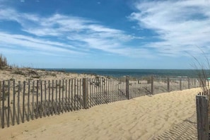 A sandy beach with a wooden fence and a clear sky. - Diamond Beach 204 (Ocean City)
