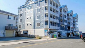 A multi-story hotel with balconies, a garage, and a sign reading 'EMERSON TOURS'. - Emerson Towers 301 (Ocean City)