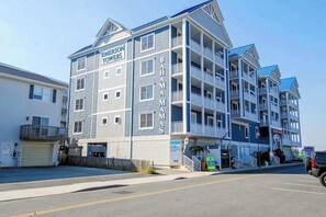 Un hotel de varios pisos con balcones, un garaje y un letrero que dice 'EMERSON TOURS'.