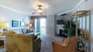 A living room with a sofa, armchairs, a television, and a fireplace. - Emerson Towers 301 (Ocean City)