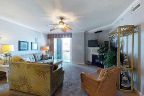 Una sala de estar con sofá, sillones, televisión y chimenea.