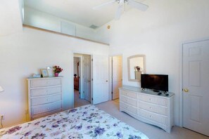 A bedroom with a bed, two dressers, a television, and a ceiling fan. - Spacious Bayside Townhouse w/Deck, Balcony, Washer/Dryer, Central A/C, Free WiFi (Ocean City)