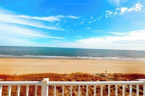 Uitzicht op het strand, met een witte balustrade op de voorgrond.