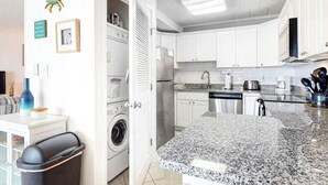 Een keuken met witte kasten, een granieten aanrechtblad, een wasmachine en een eethoek met een tafel en stoelen.