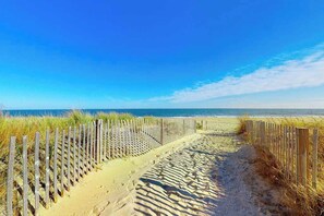 A sandy beach path with a wooden fence on one side and the ocean on the other. - Blaire Isle 301 S (Ocean City)