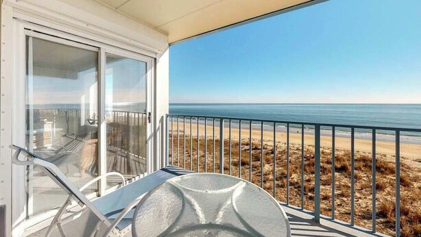 Een balkon met uitzicht op het strand en de oceaan.